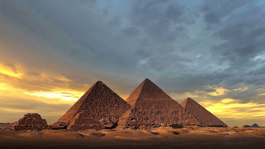 Pyramids of Giza at sunset on a cloudy day