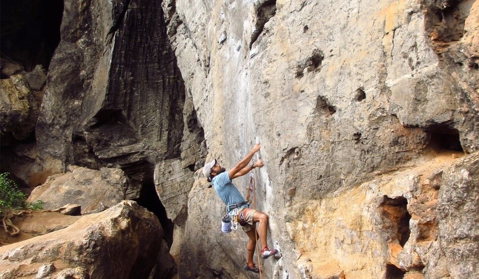 Man concentrated on a rock climbing adventure at Railay Beach in Krabi