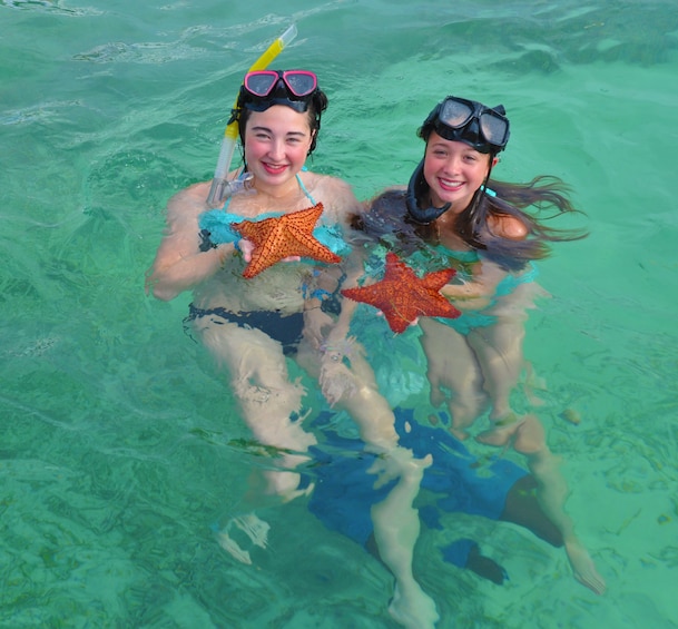 Women holding star fish in Punta Cana