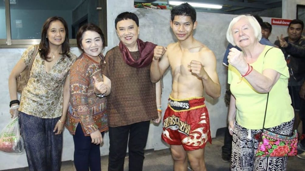 Tourists pose with Muay Thai boxer 