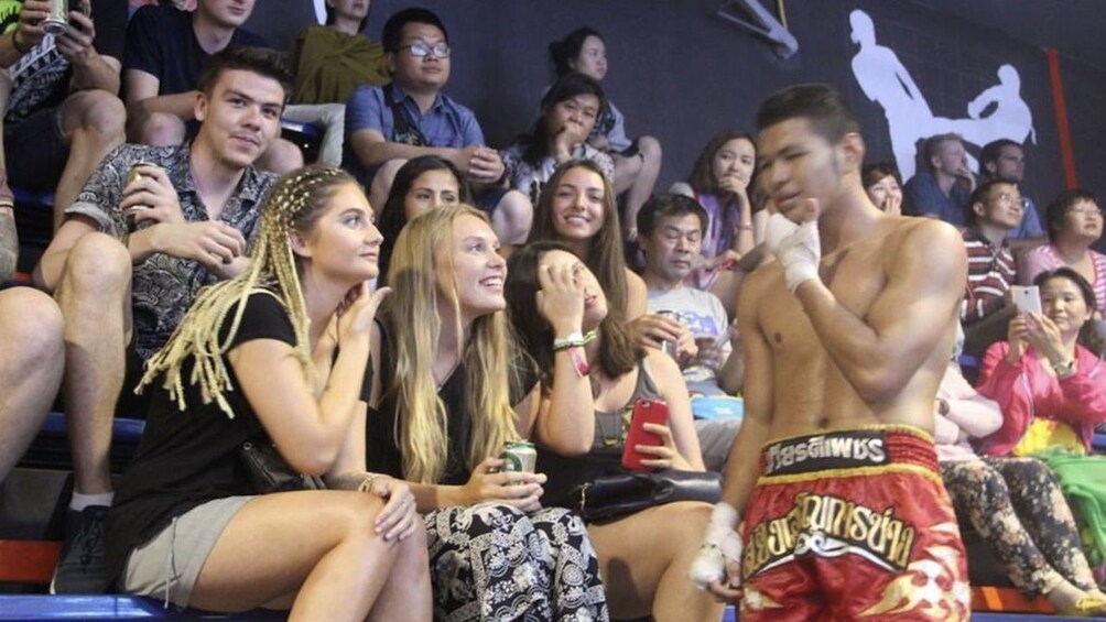 Thai boxer walks by audience in Chiang Mai, Thailand 