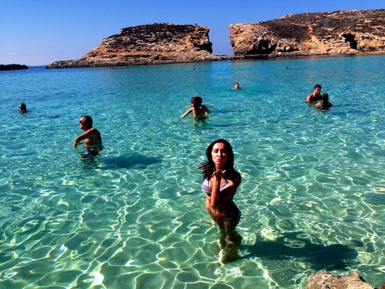 Woman poses in the clear waters of Comino Island