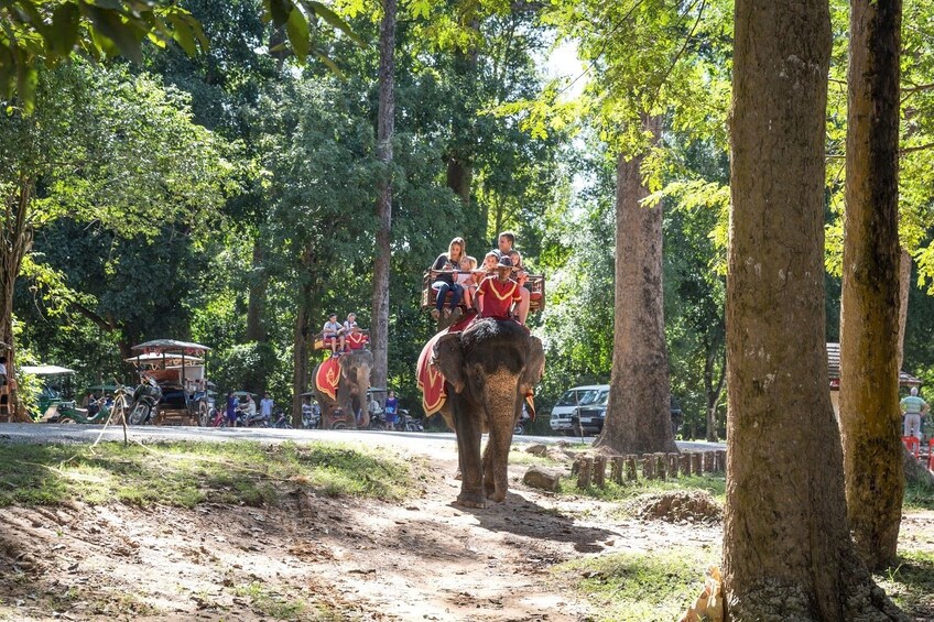 Tourists ride elephants through grounds of Bayon Temple in Siem Reap, Cambodia