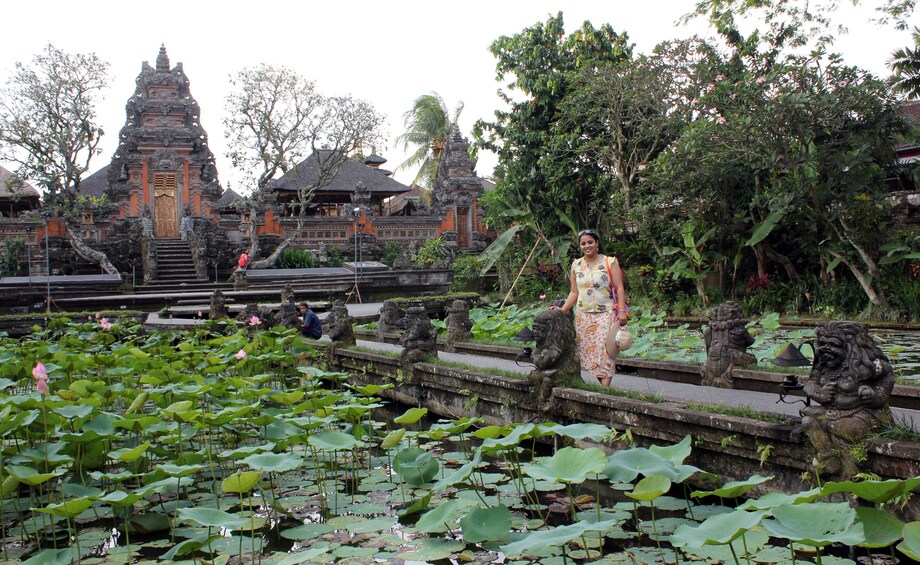 Woman poses near pond covered in lily pads at Angkor Wat Temple in Cambodia