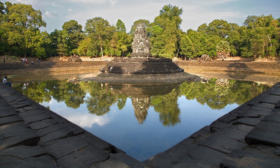 Monument and trees reflecting on water at Neak Pean