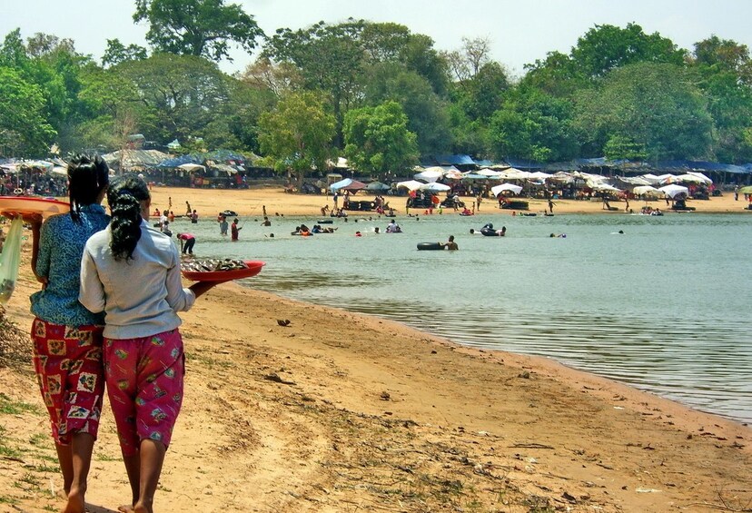 Two woman walk on the beach along West Baray Resevoir