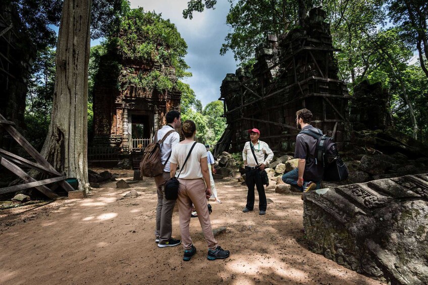 Guide speaks to tourists at Beng Mealea site in Angkor, Cambodia
