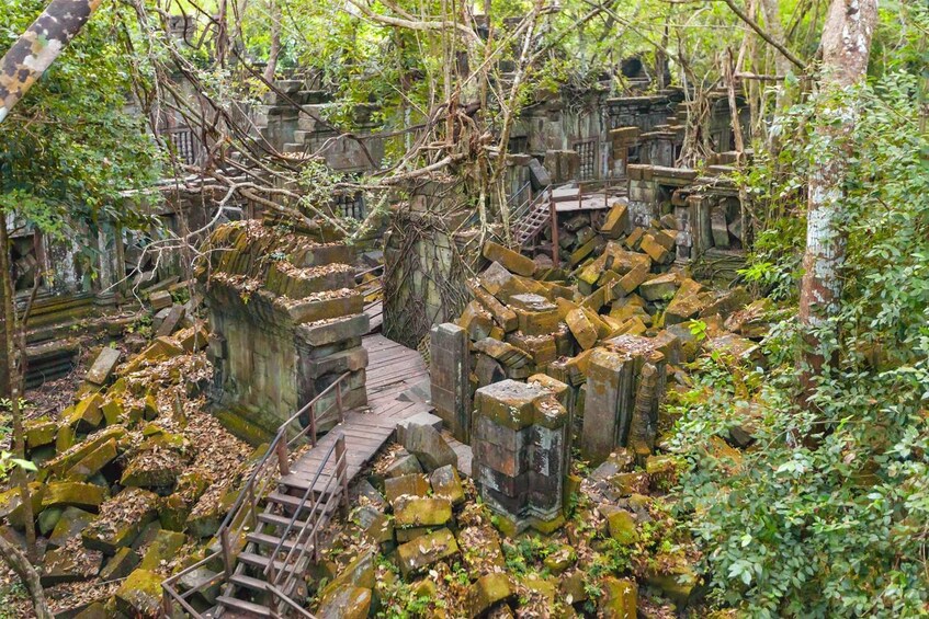 Pathway runs through moss covered ruins of Beng Mealea in Angkor, Cambodia