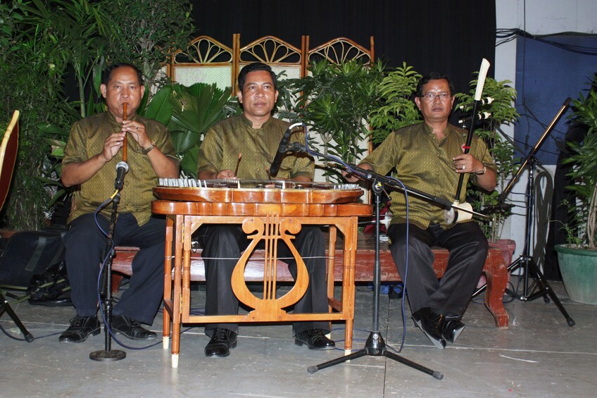 Three men pose with traditional Cambodian instruments