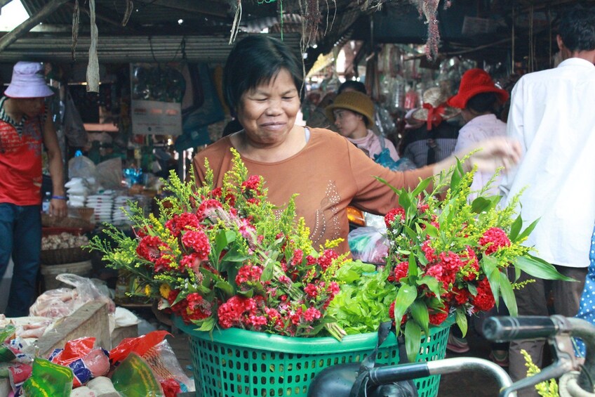 Woman with large basket of flowers at Siem Reap market