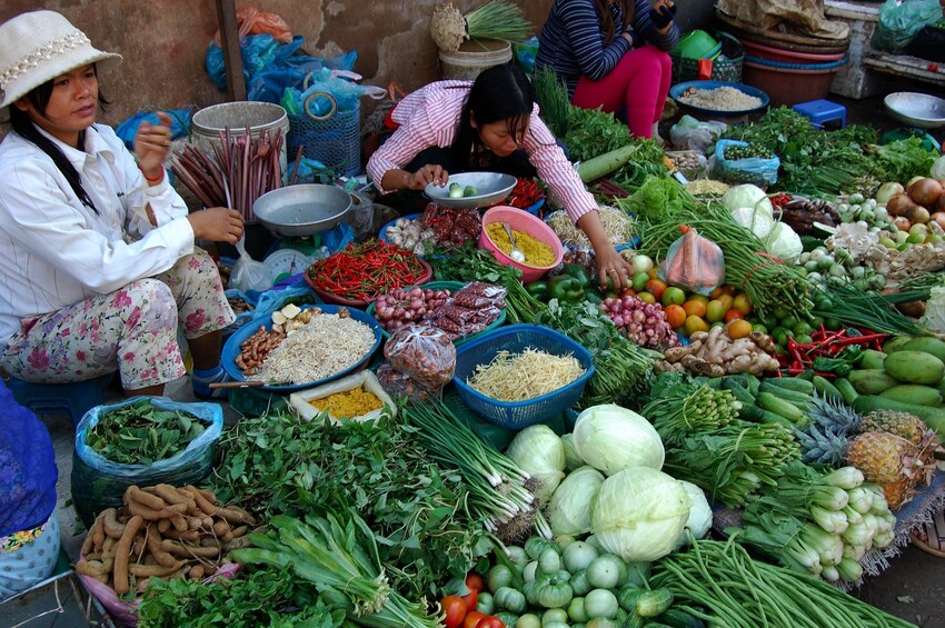 Sellers at Siem Reap market sit surrounded by produce