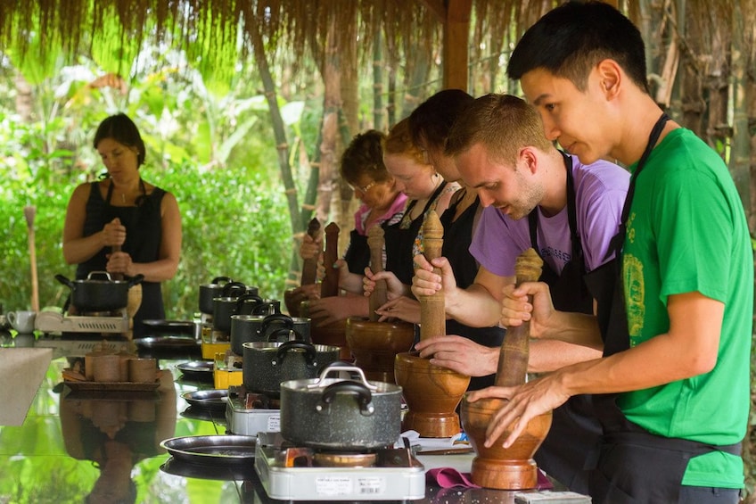 Participants muddle ingredients during Siem Reap cooking class