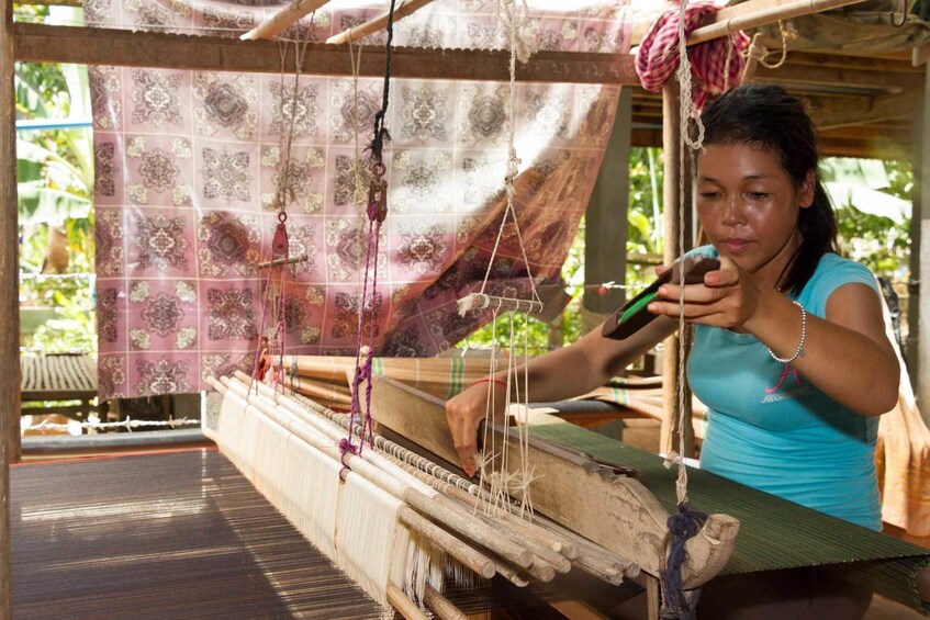 Woman looms intricate design into silk