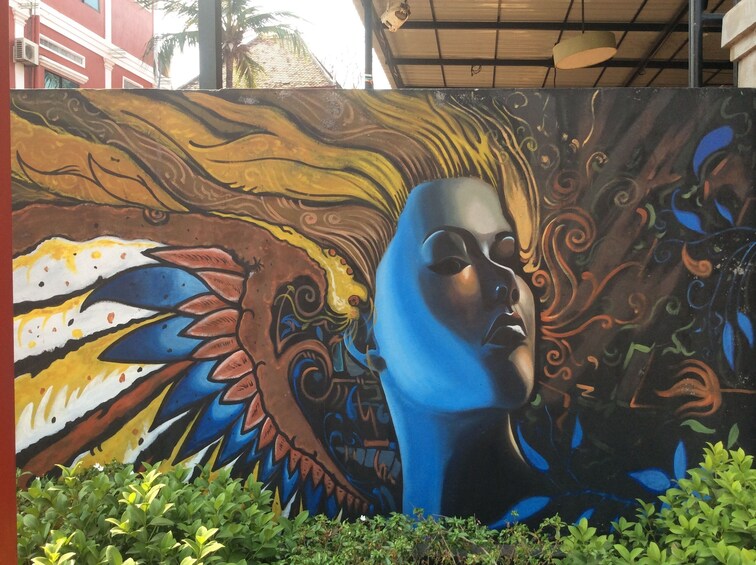 Large mural of woman with flowing hair in Cambodia