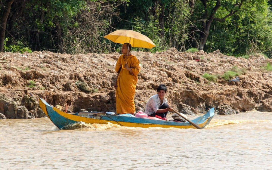 Monk and local man on a wooden boat in Kompong Khleang 