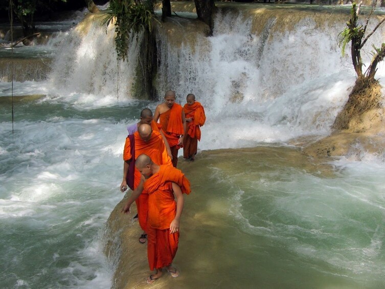 Monks walking through Tat Sae Waterfalls
