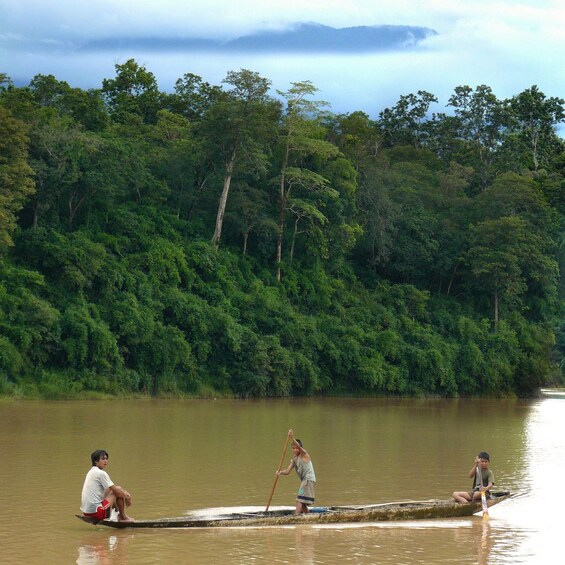 Locals on a long wooden boat on the Nam Khan River 