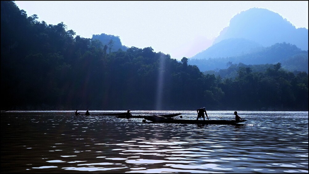 Long boats on Nam Ou River on a misty morning 
