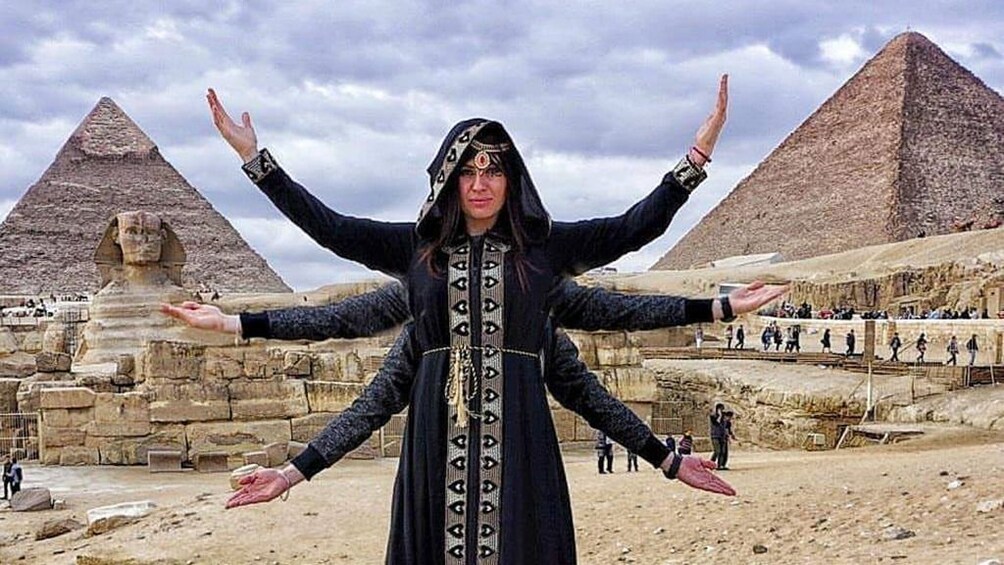 Woman poses in between two Pyramids of Giza