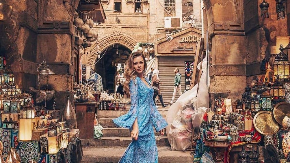 Woman in long, blue dress poses in Khan el-Khalili Market in Cairo, Egypt