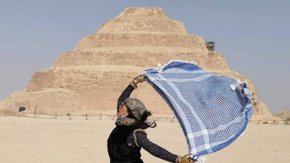 Woman with scarf poses in front of Pyramid of Djoser in Giza, Egypt