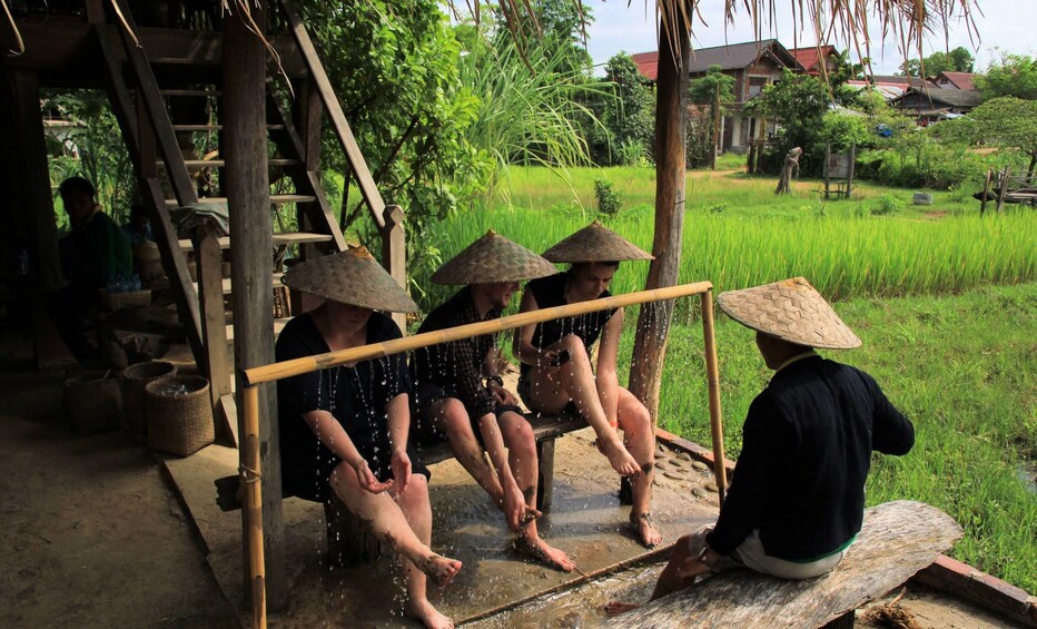 Guests washing mud and dirt off their hands and feet in Luang Prabang