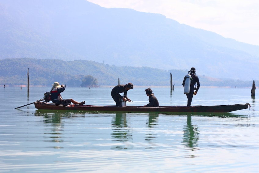 People stand up on long boat in Nam Ngum Reservoir