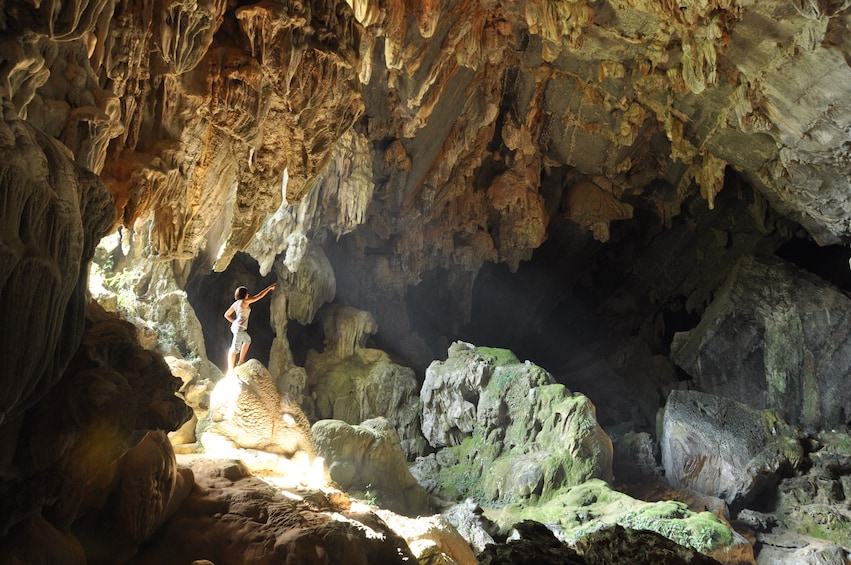 Woman stands on rock in Tham Phu Kham Cave in Vang Vieng, Laos