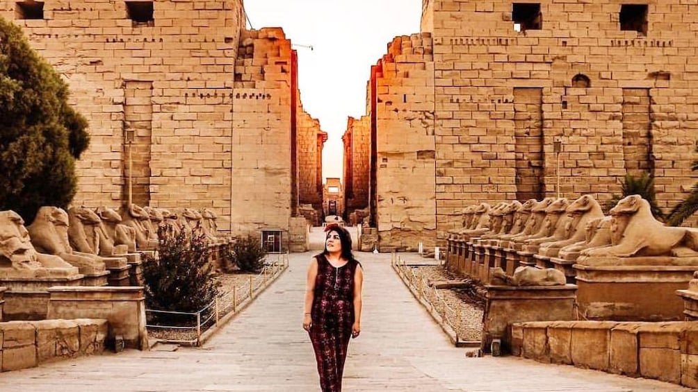 Woman walks through grounds of Karnak Temple in Luxor, Egypt
