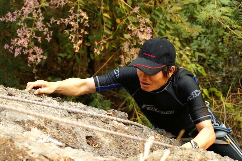 Closeup of man rock climbing in Vang Vieng, Laos