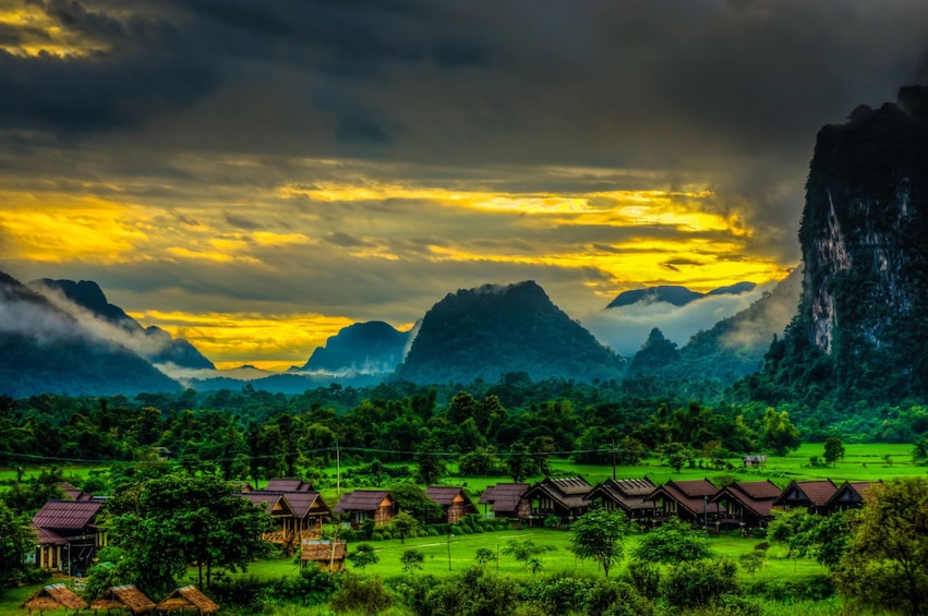 Bright sunset shines through storm clouds over Vang Vieng, Laos