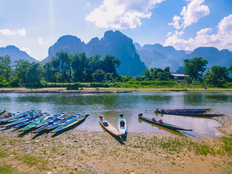 Kayaks on the shore of Nam Song River on a sunny day