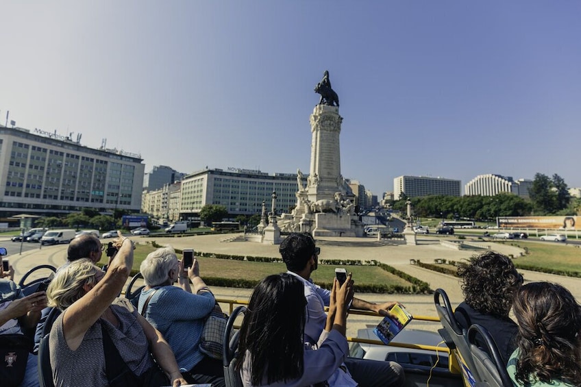 Tourists take pictures from bus of large square in Lisbon, Portugal