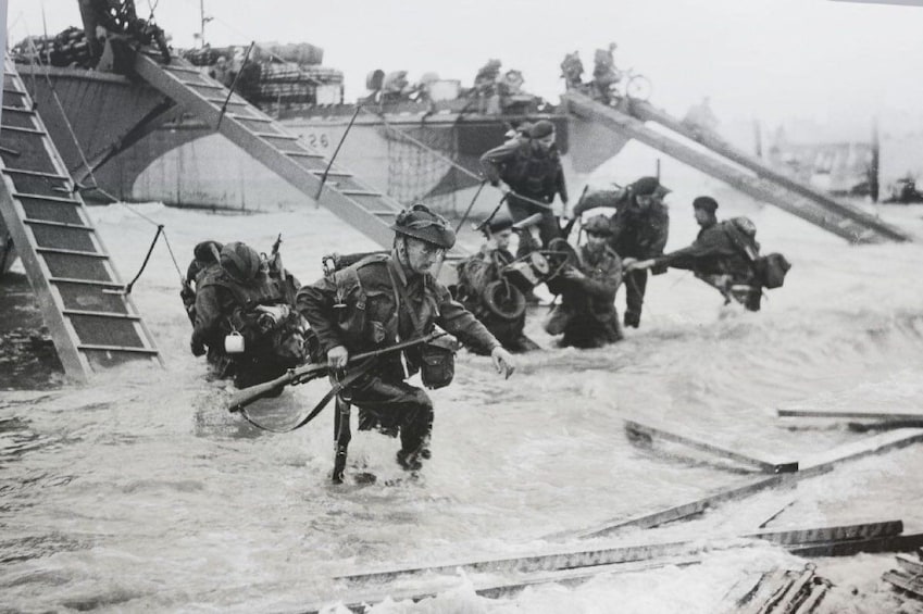 Historical photo of soldiers wading through deep water on D Day