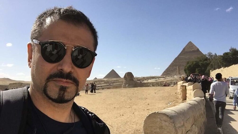 Man takes selfie with Pyramid in the background