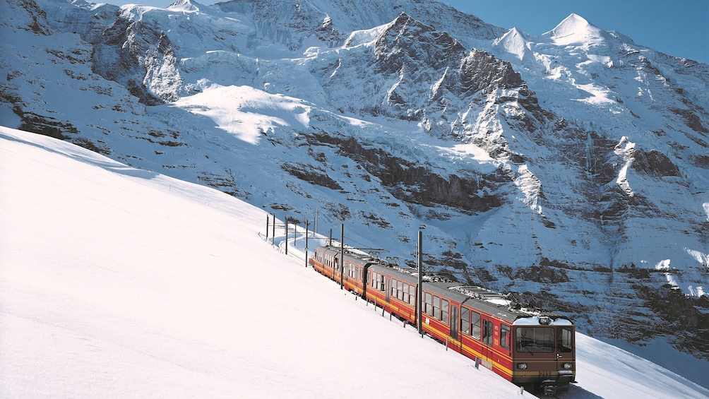 Train on snow covered hillside at Jungfraujoch Saddle in Switzerland