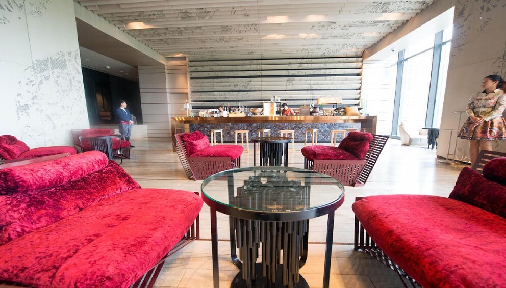 Red, velvet lounge chairs with glass table at Sofitel So Hotel