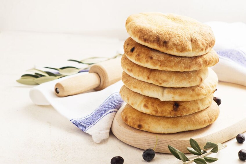 Stack of round, thick pieces of bread with rolling pin