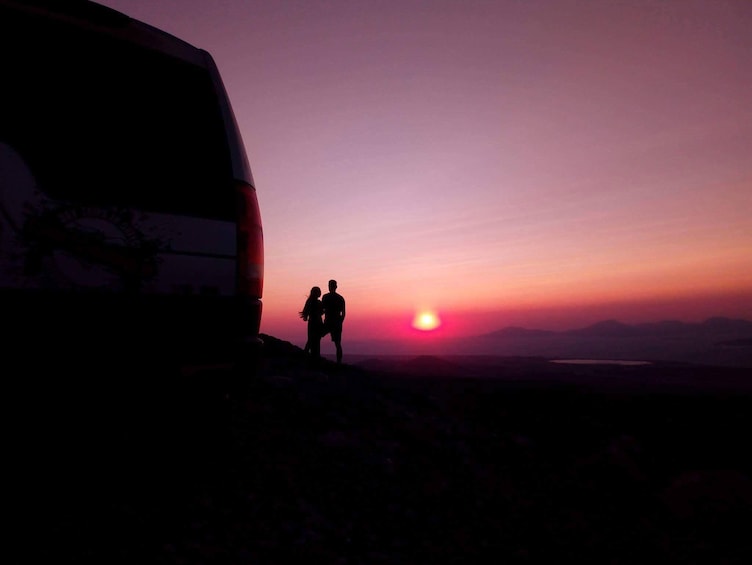 Couple stands in front of Kos sunset