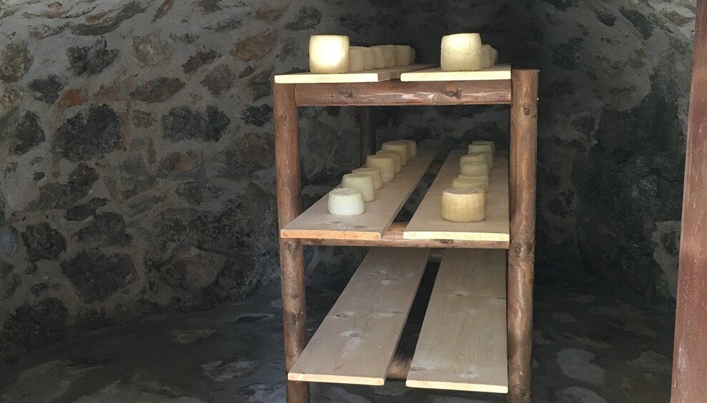 Cheese on cooling rack in stone room 