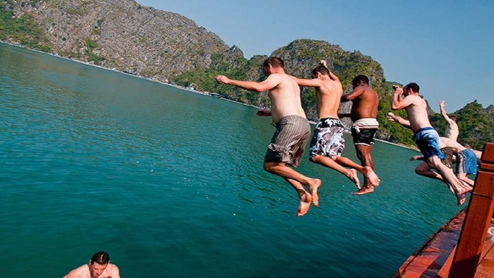 Show item 1 of 10. Friends jump off of side of boat into Lan Ha Bay, Vietnam