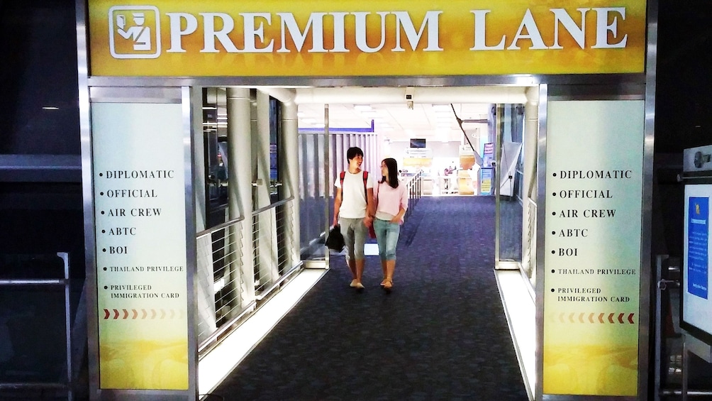 Couple walking through the Premium Lane for the Fast track Tour east Thailand inside Bangkok Don Mueang Airport (DMK)