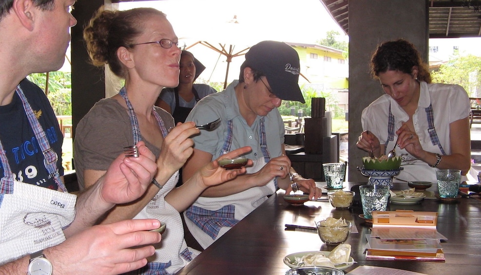 Tourists try appetizer during Thai cooking class