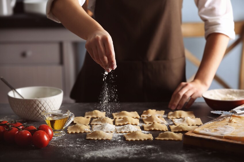 Show item 5 of 5. Person sprinkles salt on ravioli