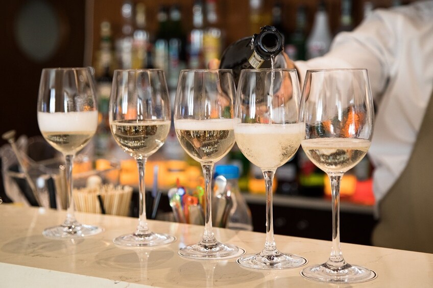 Bartender pours glasses of white wine
