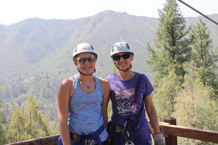 Mother and daughter pose in zip lining gear
