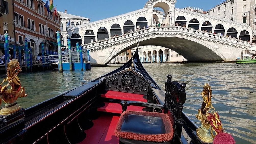 The front of a gondola and the Rialto Bridge