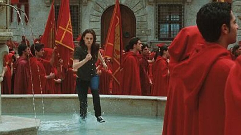 Bella Swan runs across fountain in Volterra, Italy