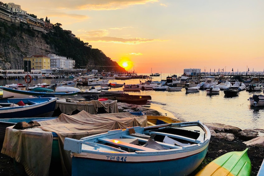Boats docked at pier on the Amalfi Coast at sunset