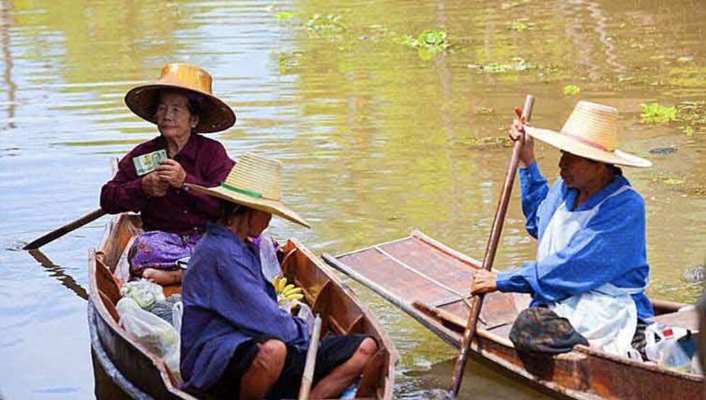 Three women in boats at Tha Kha Floating Market